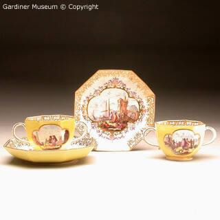Pair of two-handled cups and saucers with harbour scenes