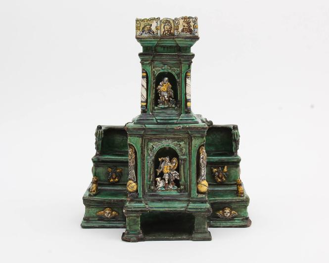 Sculpture of a stove with animals and humans