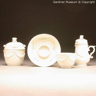 Covered sugar bowl, cup and trembleuse saucer with applied garlands