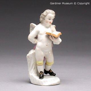 Figure of a putti in the guise of a scholar