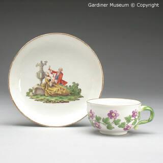 Cup and saucer with figures and flowers