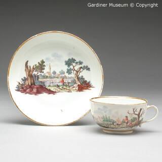 Cup and saucer with landscapes of a boy and dog