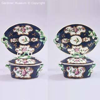 Pair of butter pots, covers and stands with floral garlands
