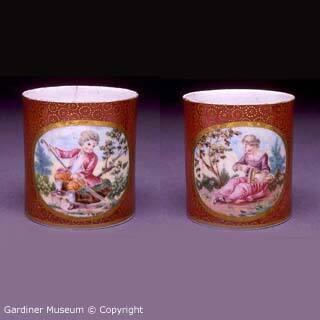 Pair of crimson ground pomade pots with pastoral figures
