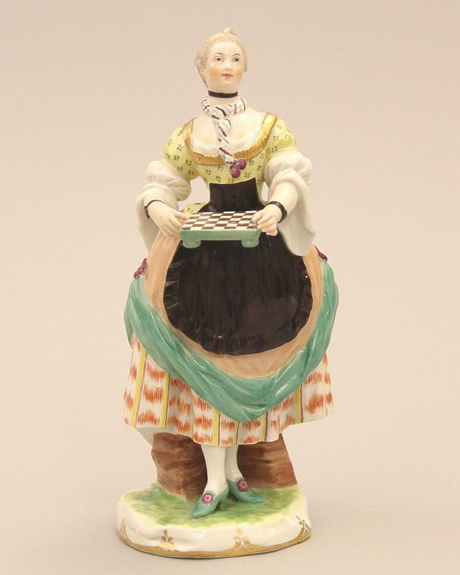 Figure of a woman holding a chess board