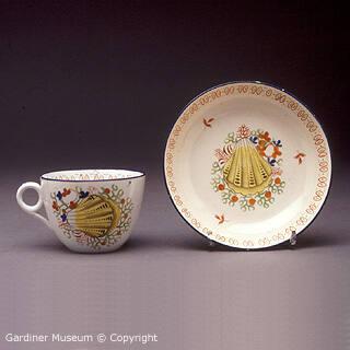 Cup and saucer with painted seashell design